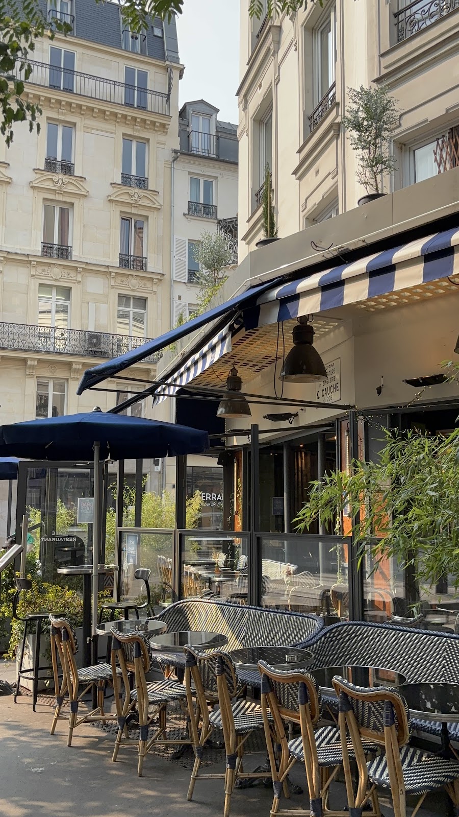 Terrasse du restaurant le Julo avec chaises bistrot store rayé bleuet blanc